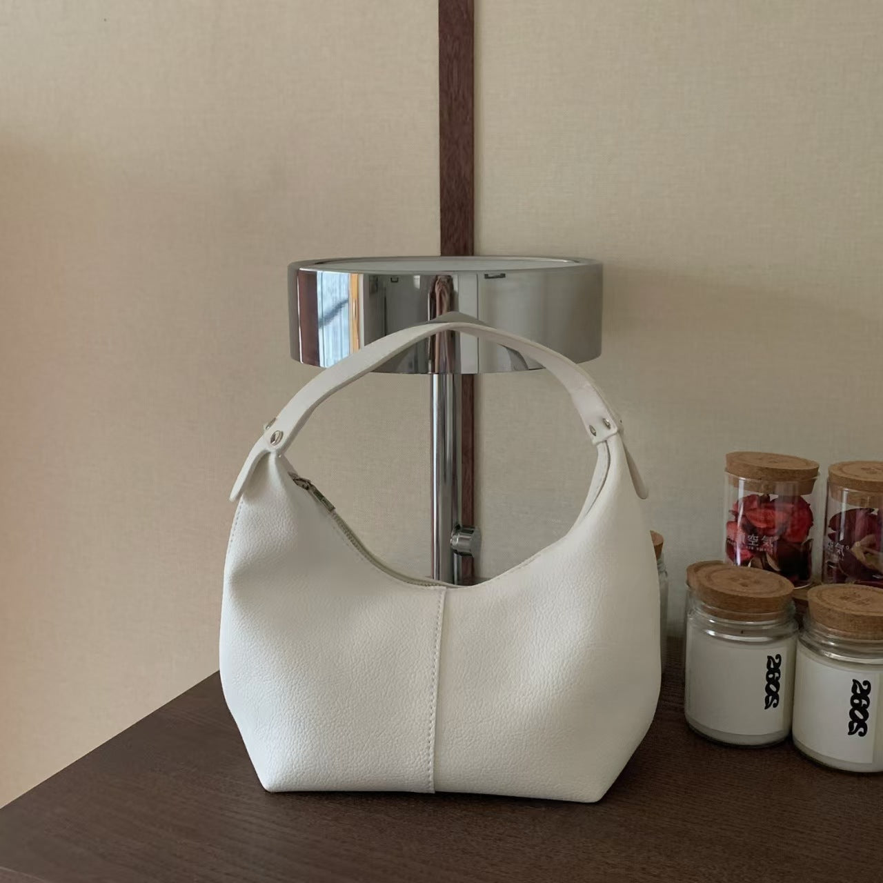 LORIAN white leather handbag on a wooden surface